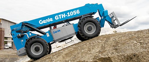 Genie telehandler driving up a hill on a construction site