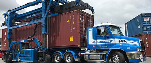 Combilift straddle carrier loading a truck with a container