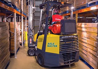 Worker using an Aisle Master LPG forklift in a warehouse
