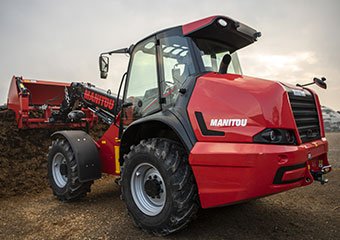 Manitou compact loader hauling silage