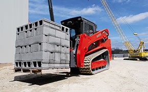 Manitou track loader hauling cement blocks