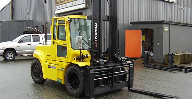 Forklift with new cylinders in front of a warehouse