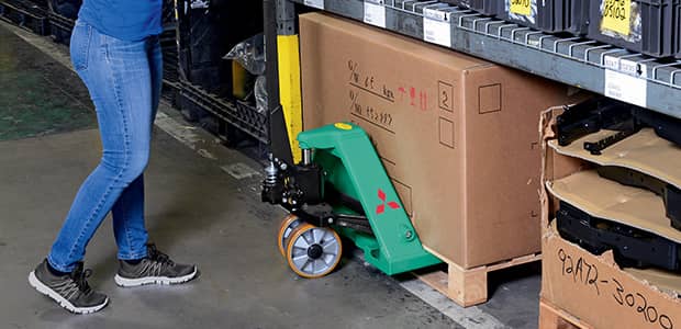 Hand pallet truck moving a box in a warehouse