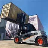 Carer electric forklift moving a container