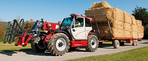 Manitou telehandler hauling hay on a trailer for the agricultural industry