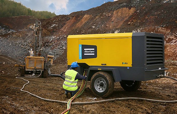 Worker using and Atlas Copco air compressor on a worksite