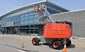 Telescopic boom lifts working on a building