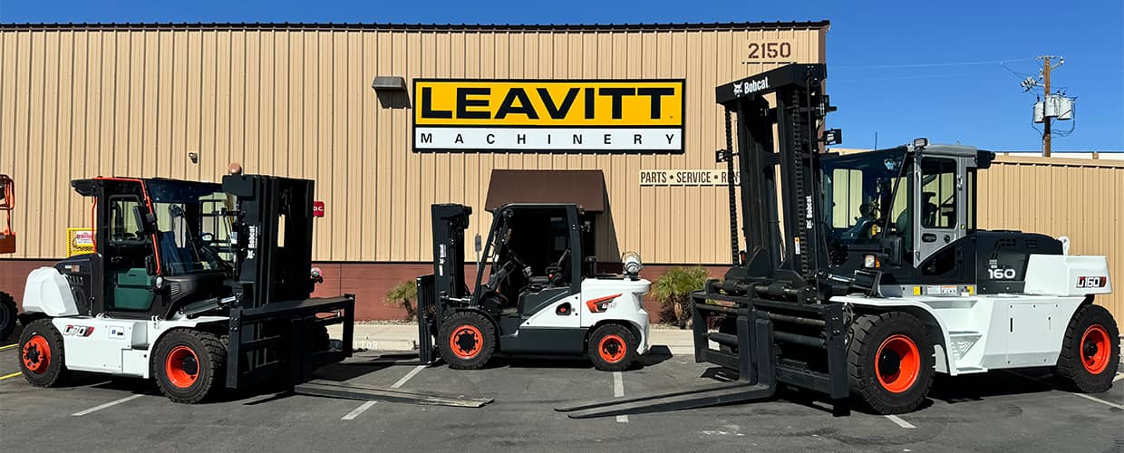 Three Bobcat forklifts in front of a Leavitt branch