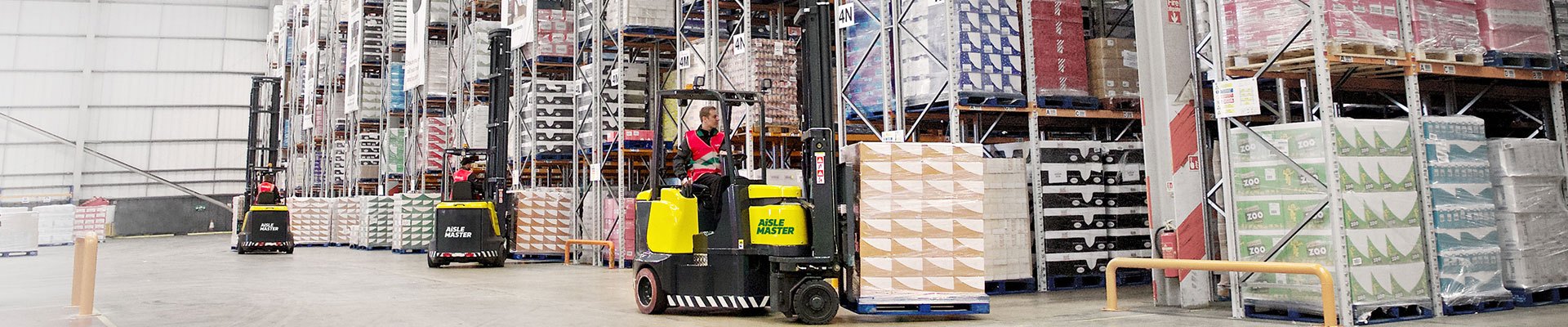 Fleet of Aisle Master forklifts in front of a building