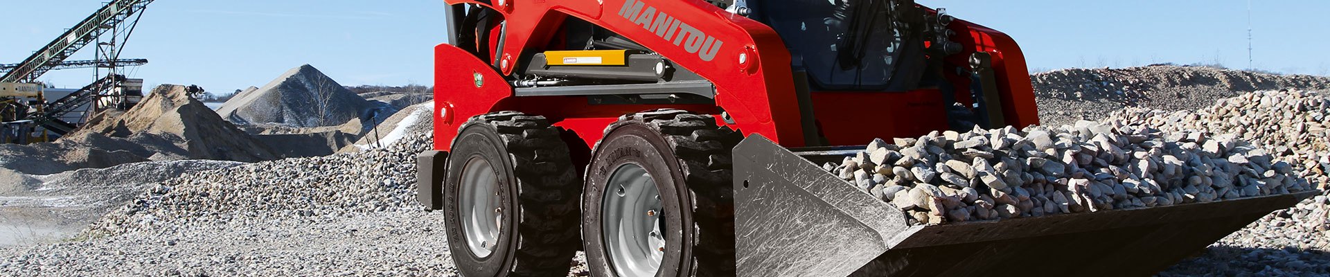 Skid steer training on worksite hauling rocks