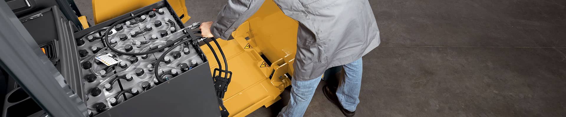 Worker removing the battery from the forklift