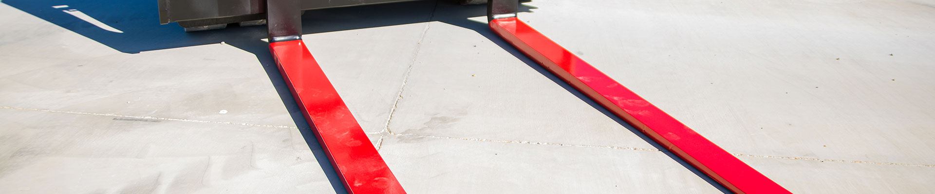 Red forklift forks attached to a forklift