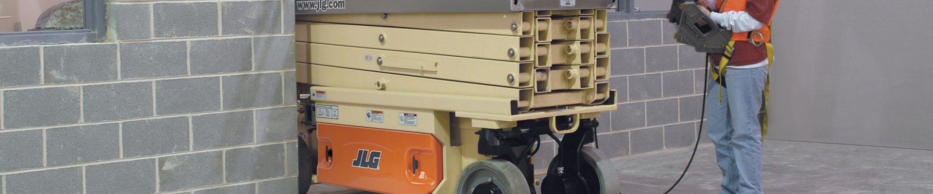 Rental of an electric scissor lift moving through a doorway