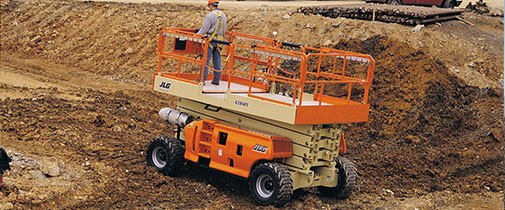 JLG scissor lift driving in dirt