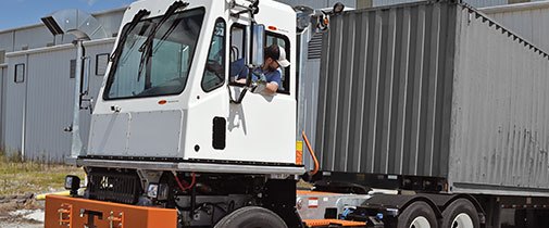 Tico yard spotter backing up to a warehouse