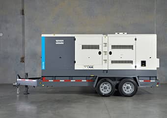 Worker using an Atlas Copco generator at a construction site