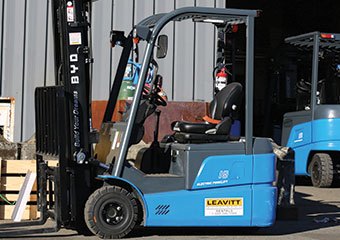 BYD 3-wheel electric forklift sitting in a yard