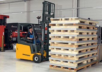 Worker using a Jungheinrich forklift in a warehouse