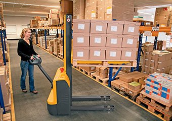 Worker using a Jungheinrich walkie stacker in a warehouse