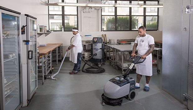 Workers using Nilfisk Advance equipment for cleaning