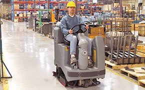 Working using a Nilfisk Advance scrubber in a warehouse