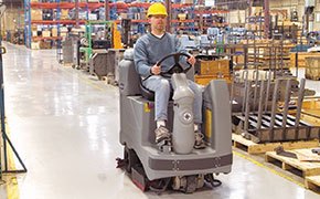 Working using a Nilfisk Advance scrubber in a warehouse