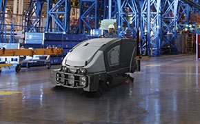 Worker using a Nilfisk Advance sweepers and scrubber in a warehouse