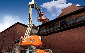 Worker using an articulating boom lift