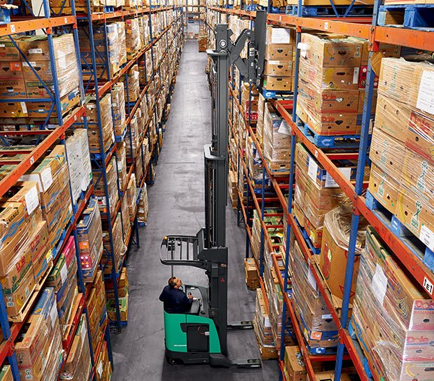 Worker using a Mitubishi reach truck in a warehouse