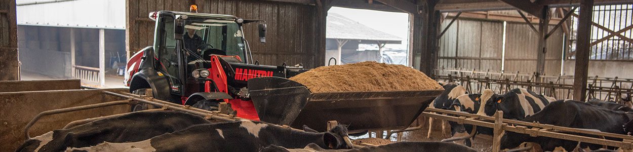 A wheel loader being used in a barn