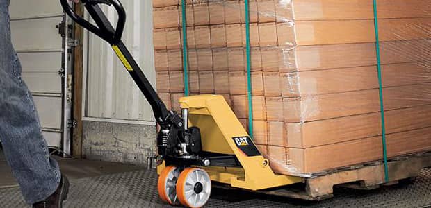 Manual pallet truck moving pallets in a warehouse