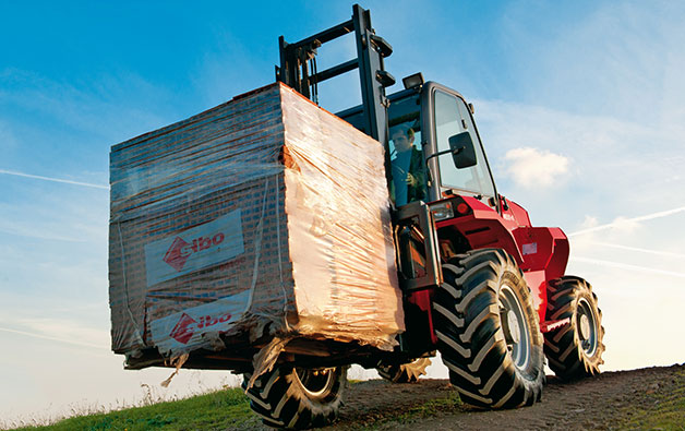 Rental of a Manitou rough terrain forklift hauling a load