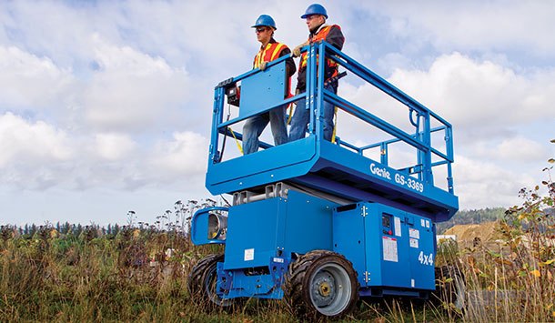 Rental of a Genie  rough terrain scissor lift driving through a field