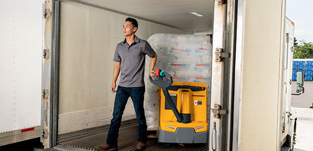 Worker pulling a loaded pallet jack