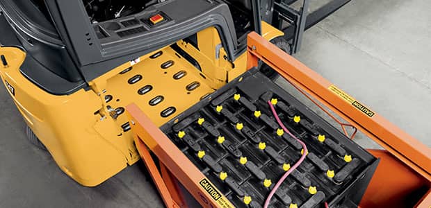 Worker safely removing a battery from a forklift