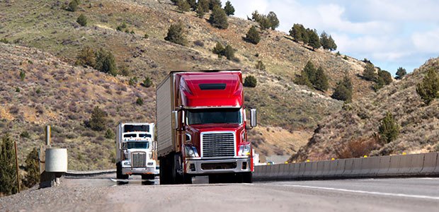 Two haul trucks that are driving down the road