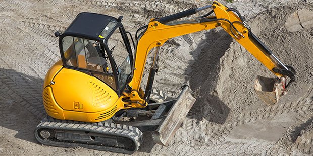 Operator driving an excavator at a site