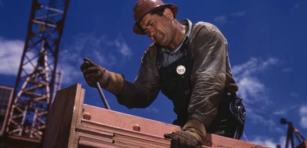 Worker rigging up iron beams at a construction site