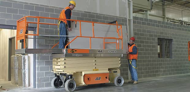 Workers operating an aerial lift  in a building