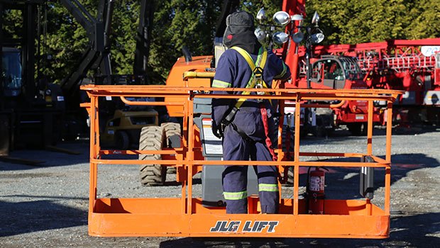 Operator training on a JLG boom lift in a yard