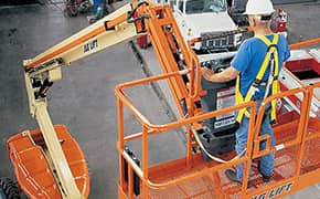 Worker wearing an orange safety harness for fall protection