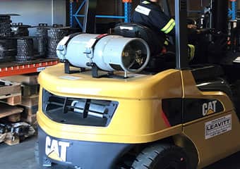 Operator driving a forklift with a propane cylinder