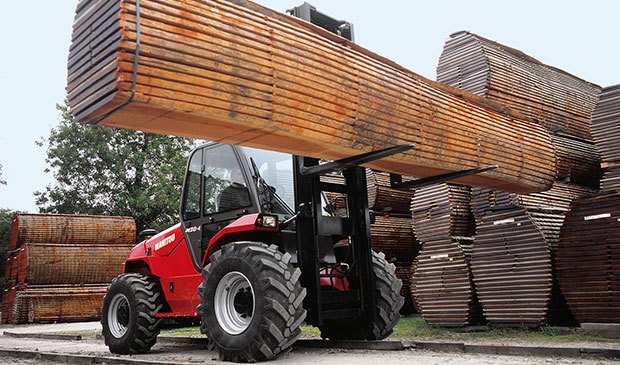 Operator trained on a rough terrain forklift hauling lumber