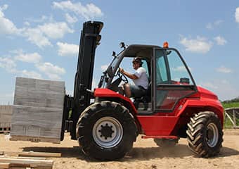 Operator driving a rough terrain forklift